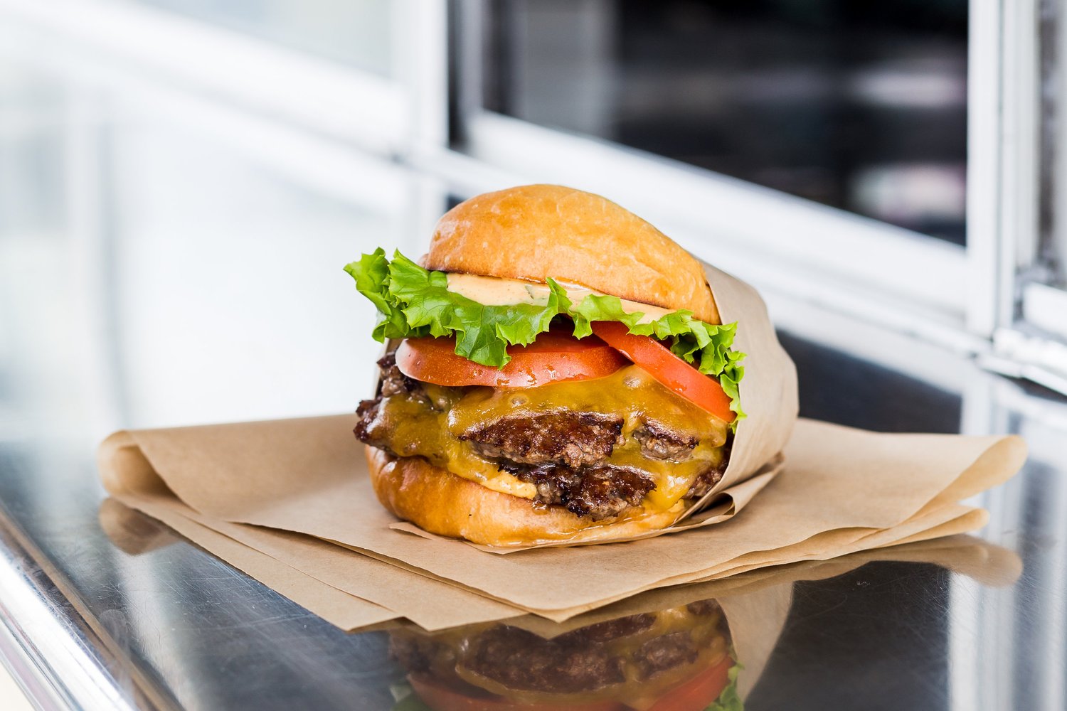 A cheeseburger from Beep’s Burgers on a paper-lined counter.