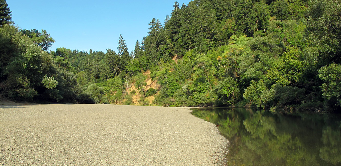 A broad gravel beach beside the Russian River at Forestville River Access.